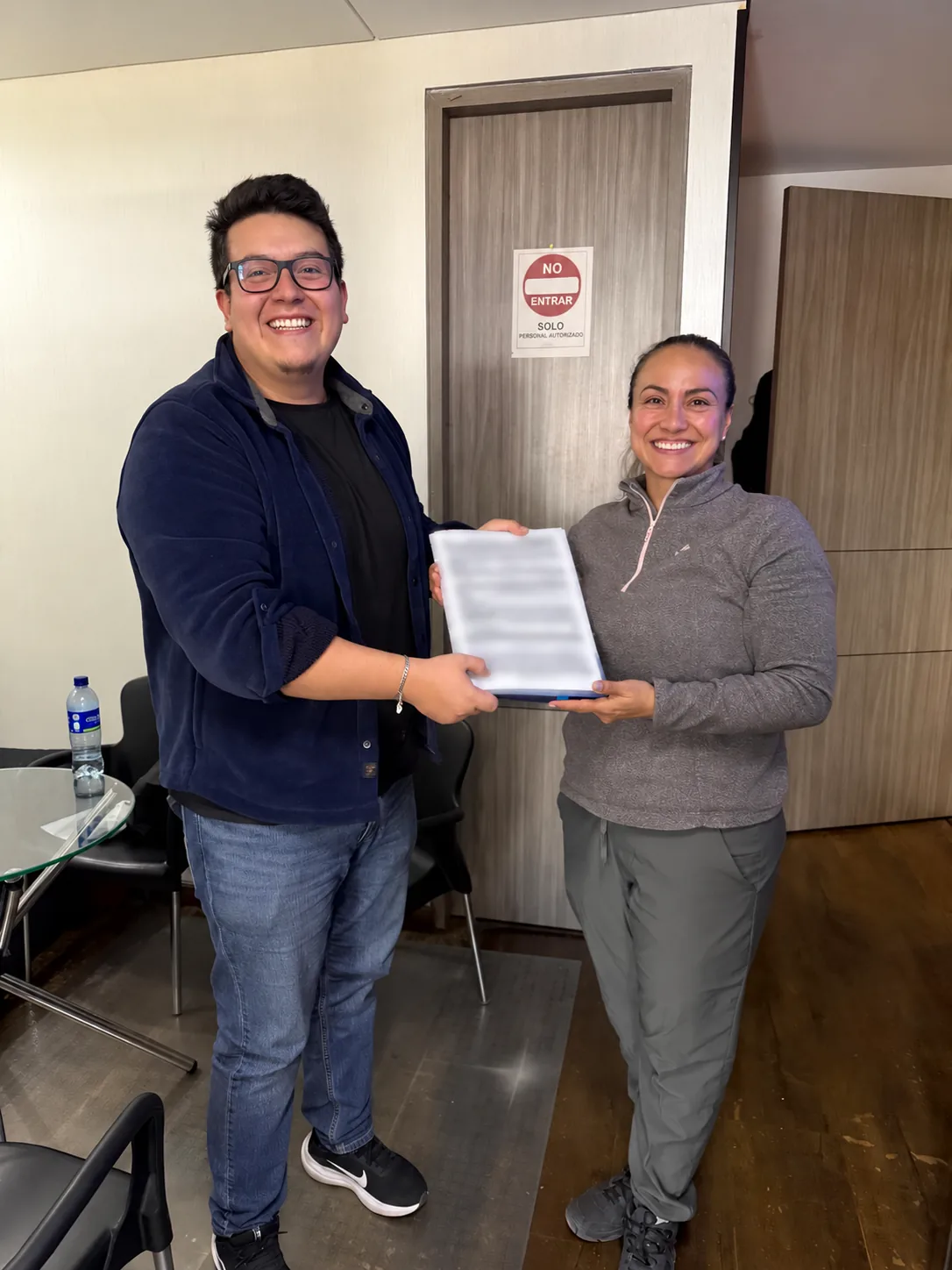 Integrante del equipo junto a una clienta durante una entrega de documentos