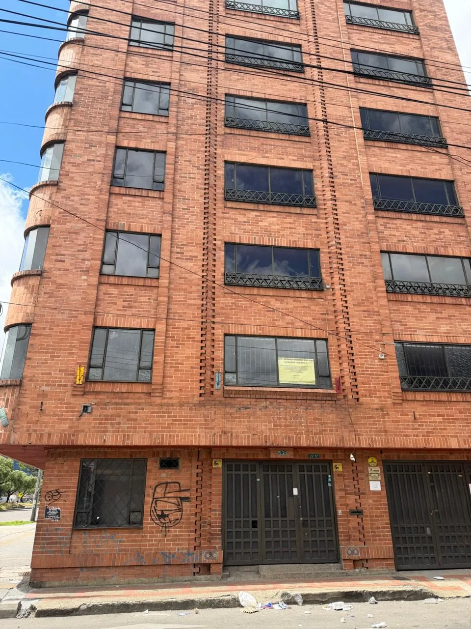 Edificación en esquina con fachada en ladrillo y ventanas curvas